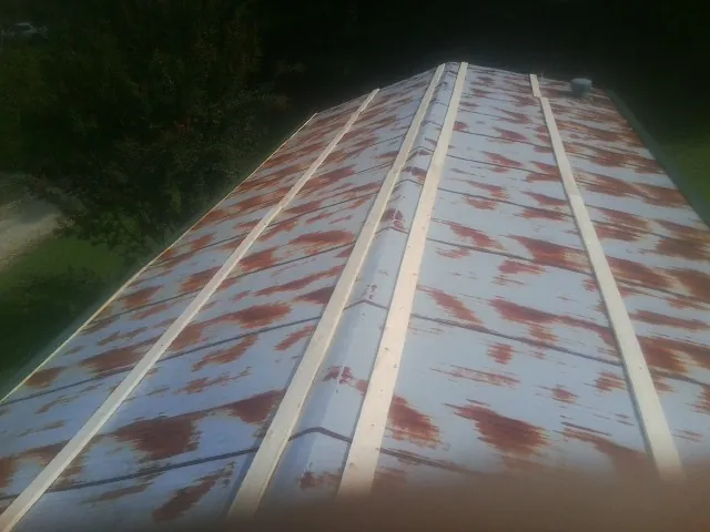 Rusted metal roof panels with new wood purlins before replacement — Storm Damage Roof Repair in Byram by Roofing Brothers